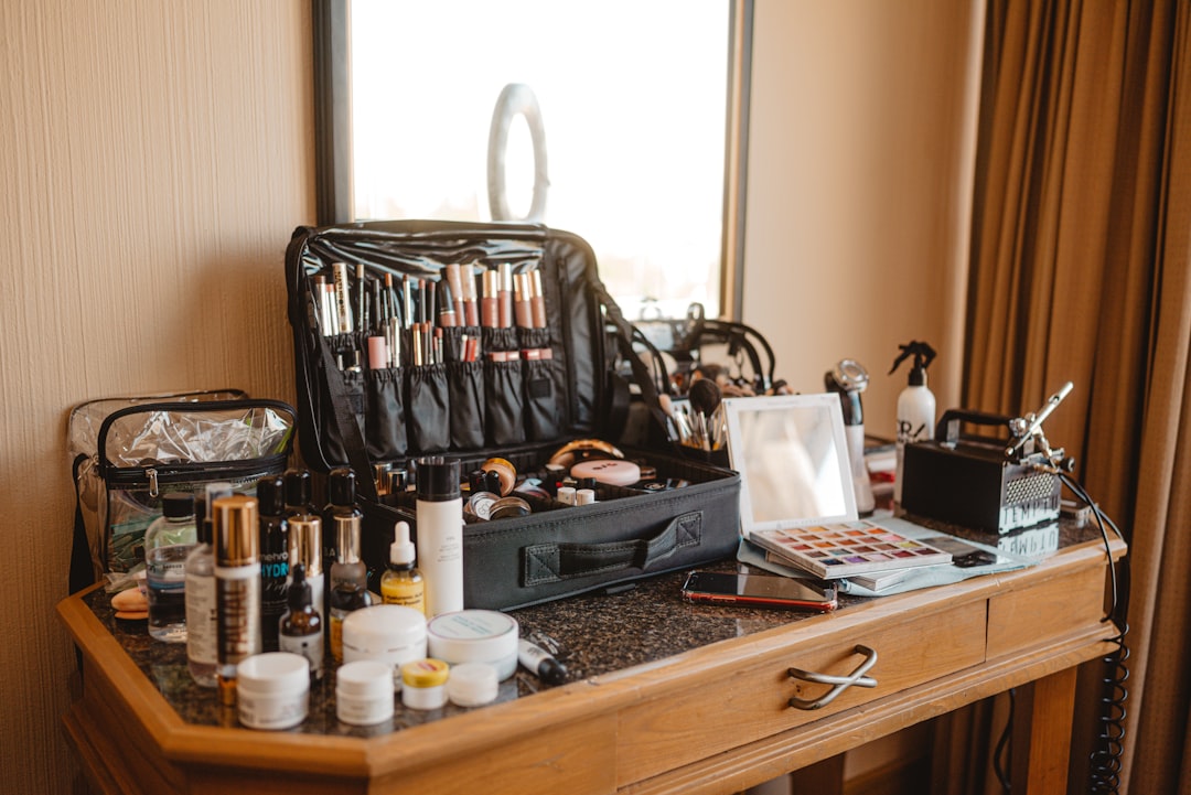 Makeup artist's kit spread across a wooden vanity table. — Photo by Fotógrafo Samuel Cruz on Unsplash