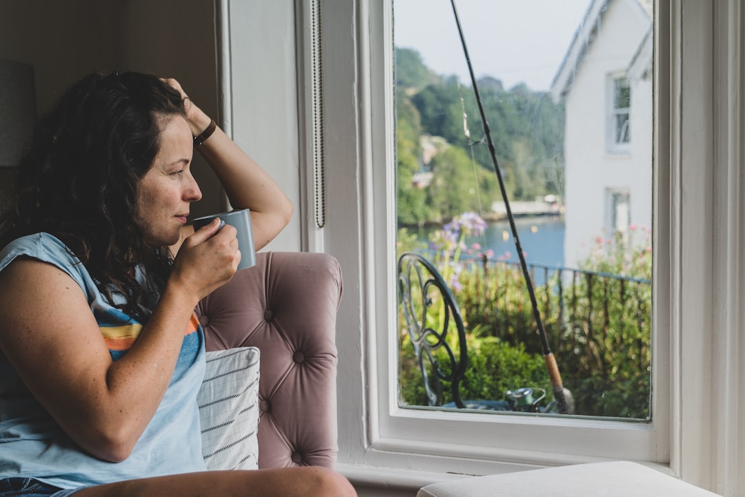 a woman sitting in a chair looking out a window — Photo by BEN ELLIOTT on Unsplash