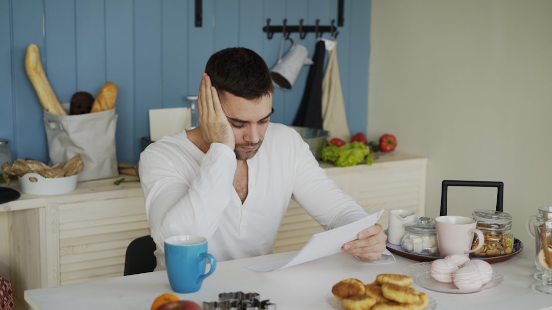 Man sitting at table reading papers with breakfast. — Photo by Vitaly Gariev on Unsplash