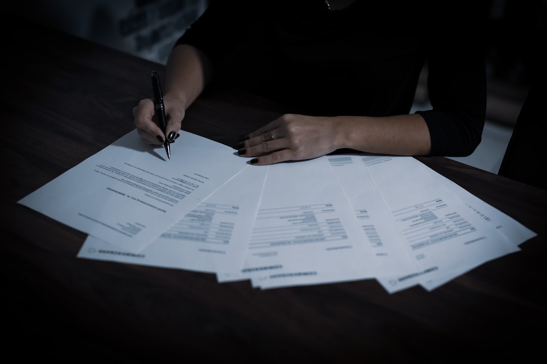 a woman sitting at a table with lots of papers — Photo by Dimitri Karastelev on Unsplash