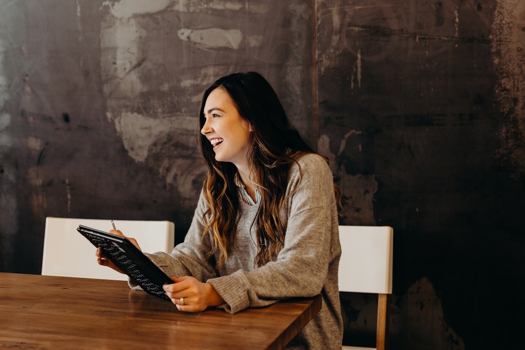 woman sitting around table holding tablet — Photo by Brooke Cagle on Unsplash