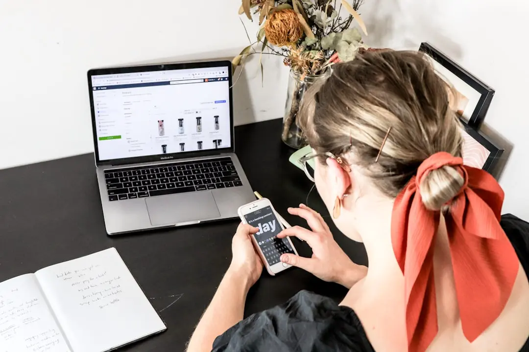 woman in orange shirt using iphone — Photo by S O C I A L . C U T on Unsplash
