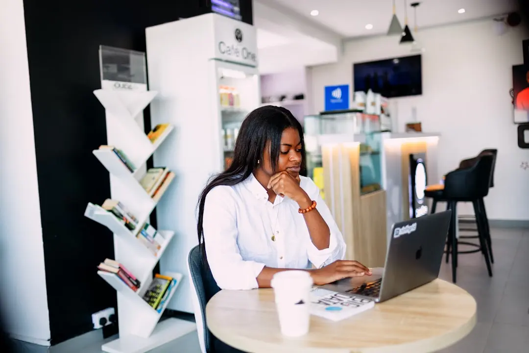 A woman sitting at a table with a laptop — Photo by Ninthgrid on Unsplash