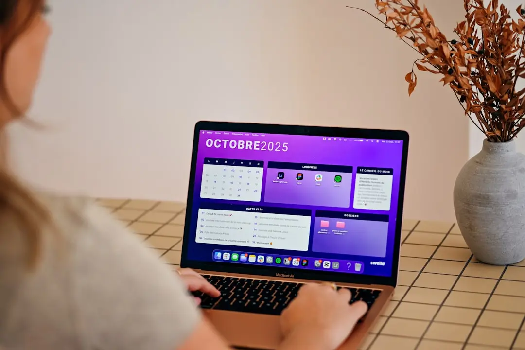 Woman using laptop with october 2025 calendar displayed. — Photo by Swello on Unsplash
