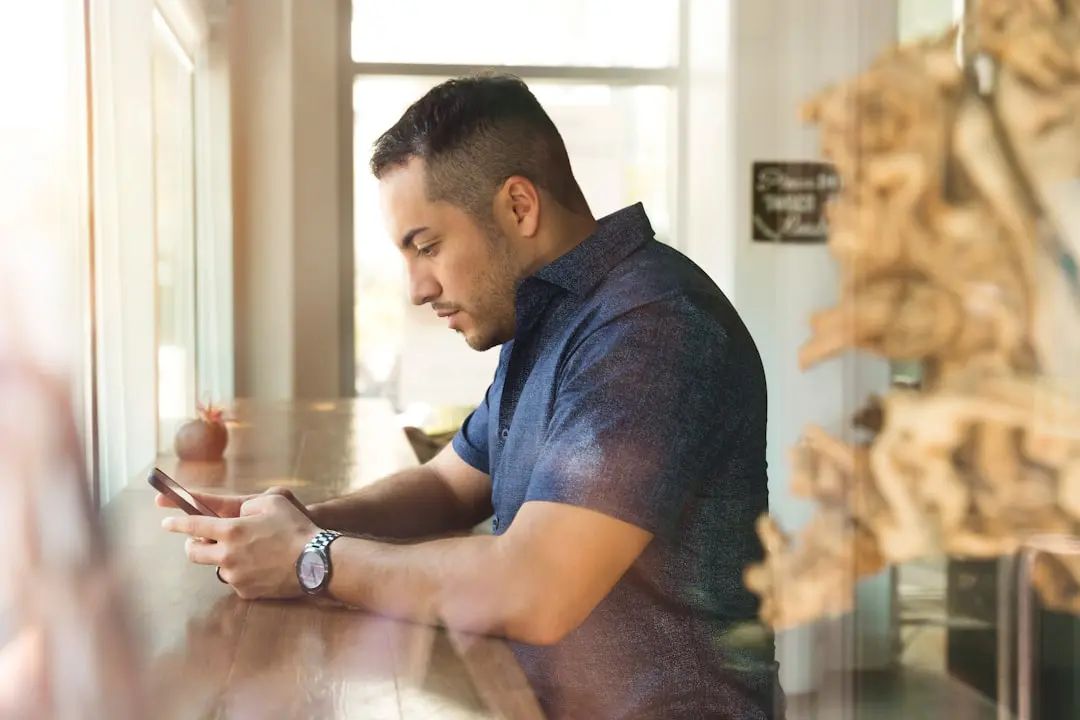 man in black button-up shirt holding smartphone — Photo by LinkedIn Sales Solutions on Unsplash