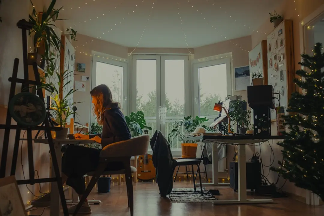 Woman working at a desk in a cozy, plant-filled room. — Photo by Hanna Lazar on Unsplash