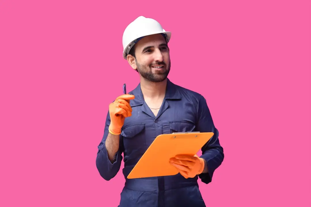 a person wearing a hard hat and holding a pen — Photo by Fotos on Unsplash