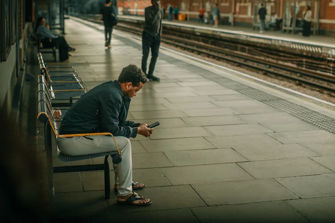 A man sitting on a bench looking at his cell phone — Photo by Gilley Aguilar on Unsplash