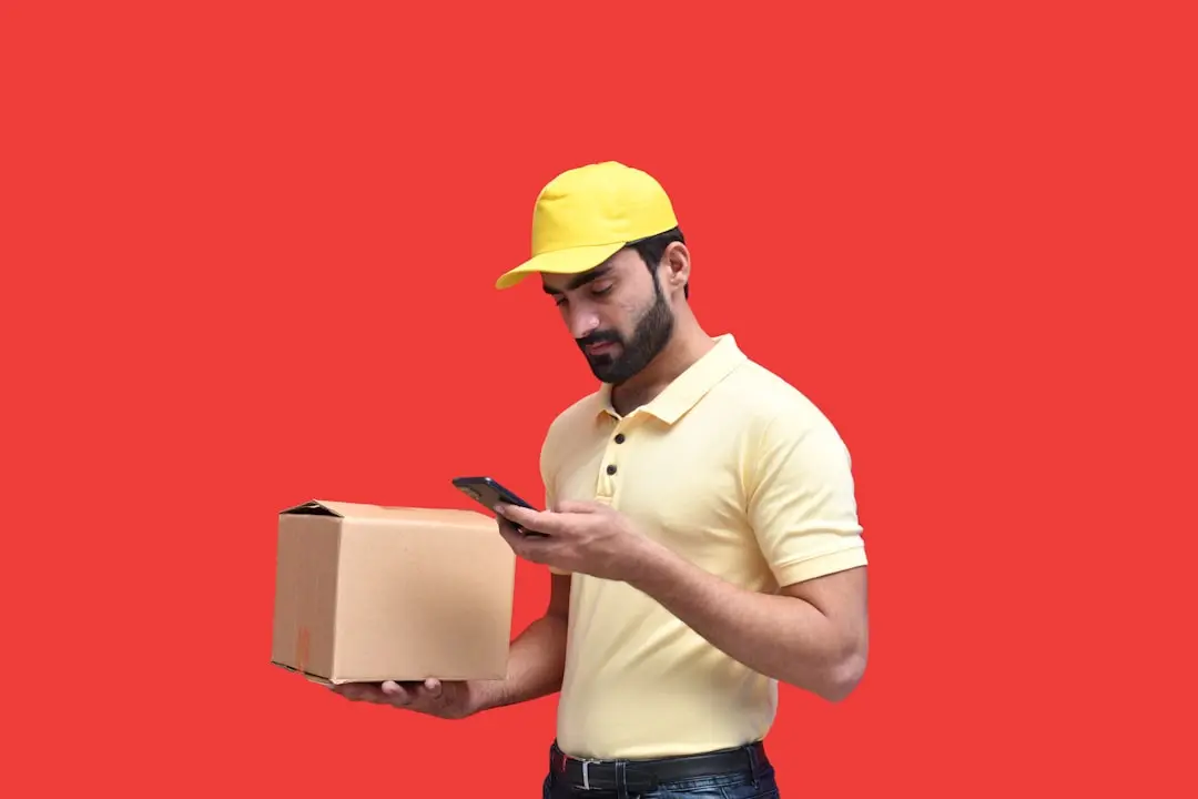 a man in a yellow hard hat looking at a phone — Photo by Fotos on Unsplash