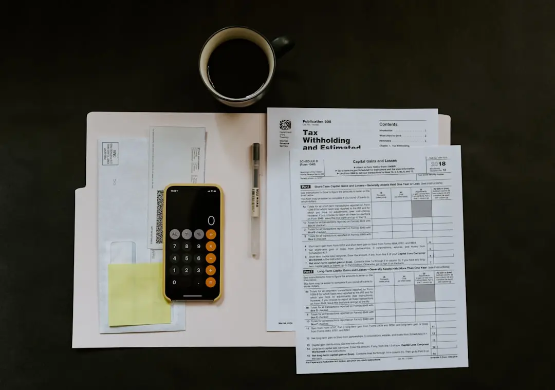 black Android smartphone near ballpoint pen, tax withholding certificate on top of white folder — Photo by Kelly Sikkema on Unsplash