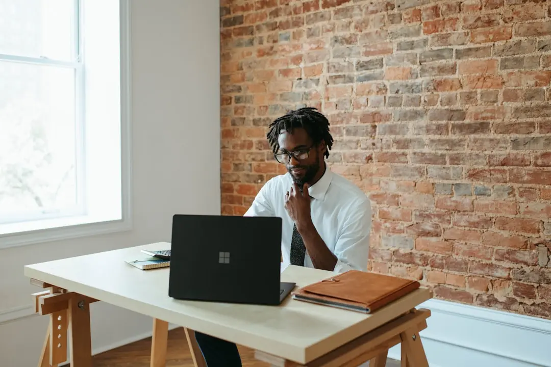 a man sitting at a table in front of a laptop — Photo by Microsoft 365 on Unsplash