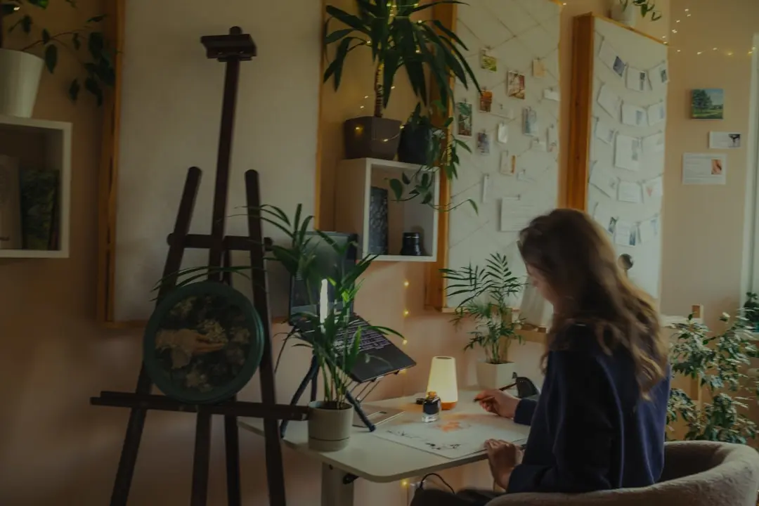 Young woman drawing at a desk in a cozy room. — Photo by Hanna Lazar on Unsplash