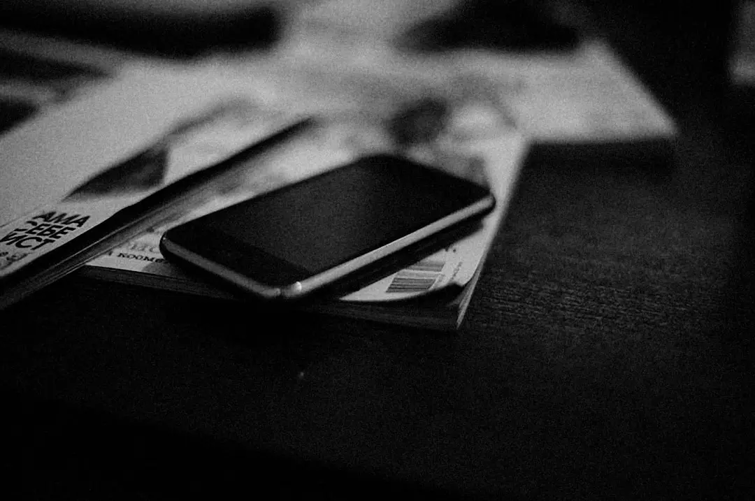 a cell phone sitting on top of a pile of money — Photo by Alexey Demidov on Unsplash
