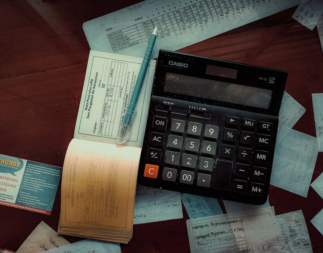 a calculator sitting on top of a wooden table — Photo by FIN on Unsplash