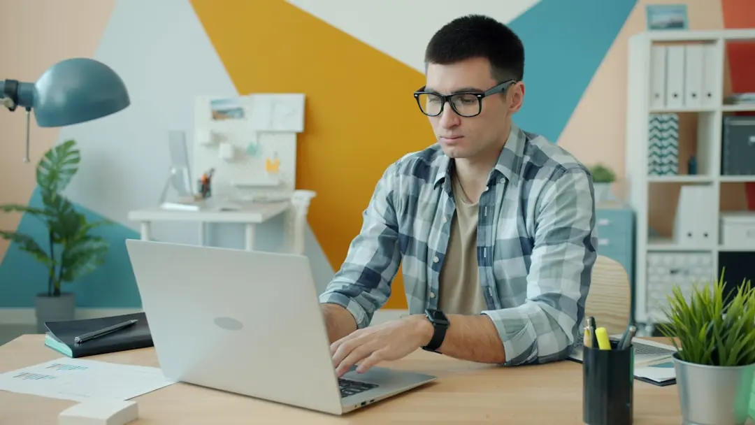 Man wearing glasses typing on a laptop at a desk. — Photo by Vitaly Gariev on Unsplash
