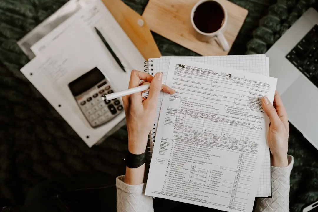 Person reviewing documents with calculator and laptop. — Photo by Kelly Sikkema on Unsplash